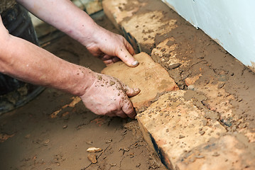 Image showing Mason hands at bricklaying works