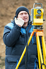 Image showing surveyor works with theodolite tacheometer