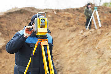 Image showing surveyor works with total station tacheometer