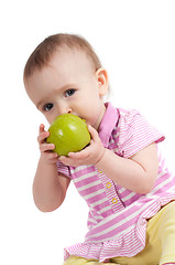 Image showing Baby girl in pink eating apple