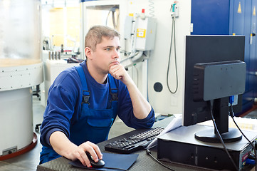 Image showing worker operating CNC machine center