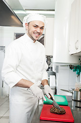 Image showing chef cutting beef steak on board