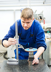 Image showing worker measuring cutting tool