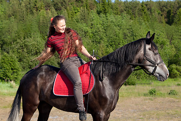 Image showing Beautiful girl on black horse