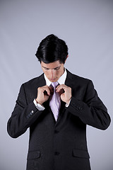 Image showing Businessman tying his necktie