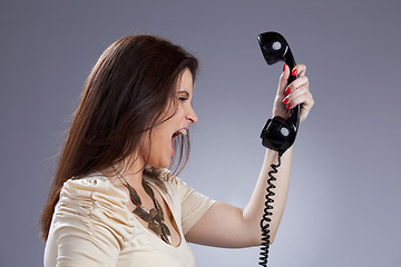 Image showing Angry woman screaming to the telephone