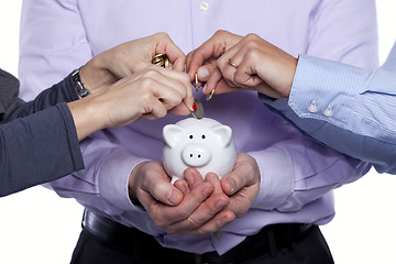 Image showing Hands inserting money in the piggybank