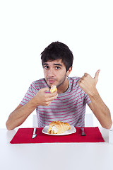 Image showing Young man eating a cake