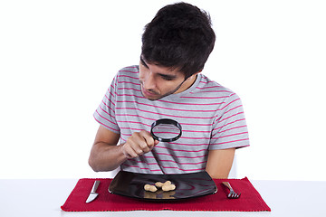 Image showing Man looking to a peanut