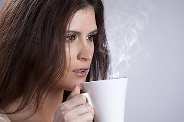 Image showing Woman drinking a hot drink