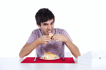 Image showing Young man eating a cake