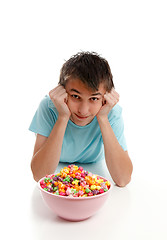 Image showing Boy relaxes with bowl of snack food