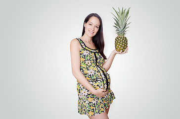 Image showing pregnant woman holding pinapple 