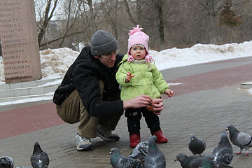 Image showing The girl with the father feed pigeons