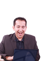 Image showing Happy young man working on laptop computer, having fun