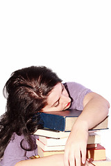 Image showing Young beautiful woman sleeping with books in a white background