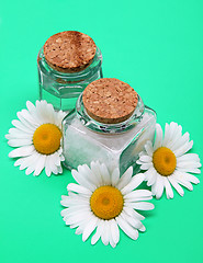 Image showing Bottles of essential oil and sea salt with white camomiles 