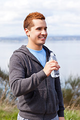 Image showing Mixed race man holding water bottle