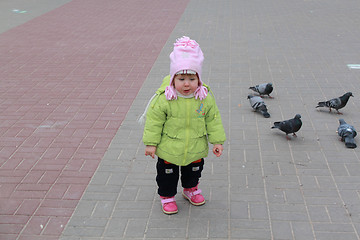 Image showing girl walks in park and feeds birds