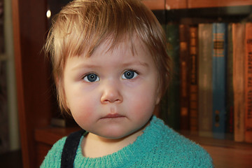 Image showing girl costs near a shelf with books