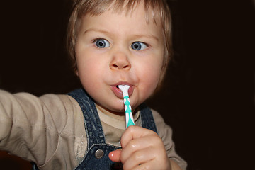 Image showing child brushes teeth