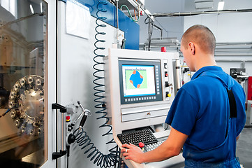 Image showing worker operating CNC machine center