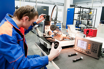 Image showing laborer checking tool with optical device