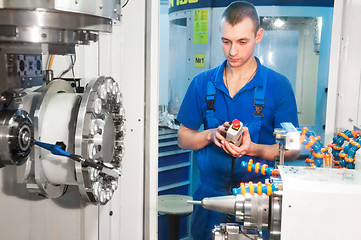 Image showing worker operating CNC machine center