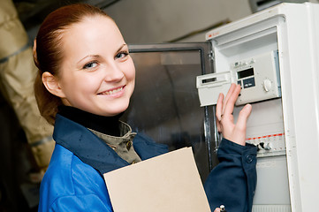 Image showing cheerful woman engineer in a boiler room