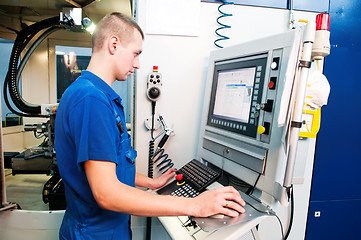 Image showing worker operating CNC machine center