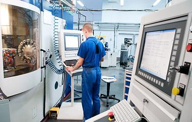 Image showing worker operating CNC machine center