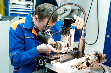 Image showing worker checking tool with optical device