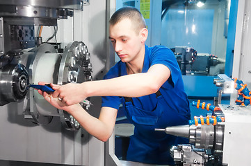 Image showing worker operating CNC machine center