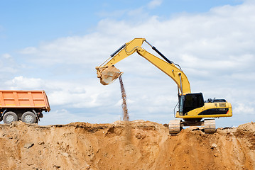 Image showing Excavator loading dumper truck