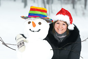Image showing happy girl and snowman in winter