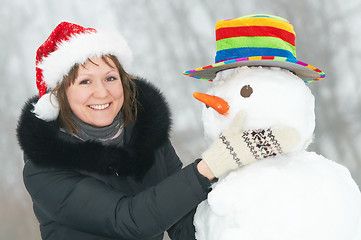 Image showing happy girl and snowman in winter