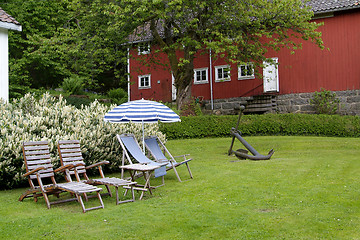 Image showing Chairs and parasol in a garden