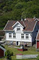 Image showing Wooden houses in a garden by the sea