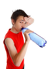 Image showing Sweaty boy drinking bottled water