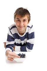 Image showing Boy eating blueberries