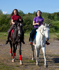 Image showing Two girls walking on horseback