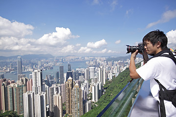 Image showing Tourist taking photo of Hong Kong skyline by his digital camera 