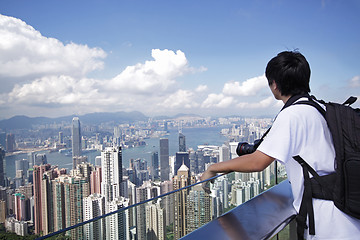 Image showing Tourist taking photo of Hong Kong skyline by his digital camera 