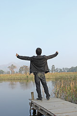 Image showing Man resting on a pontoon by a lake 