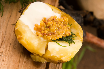 Image showing Baked potato with sour cream, grain Dijon mustard and herbs