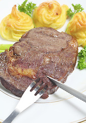 Image showing Cutting ribeye steak vertical