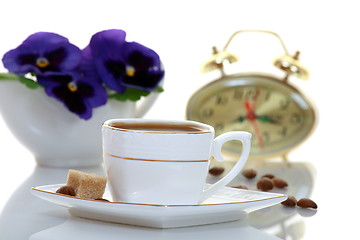 Image showing A cup of coffee with a clock and a bouquet of flowers.