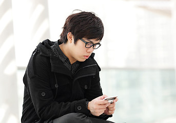 Image showing man sms on cell phone