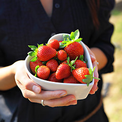 Image showing strawberry in heart shape bowl with hand