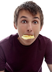 Image showing Boy mouthful potato chips